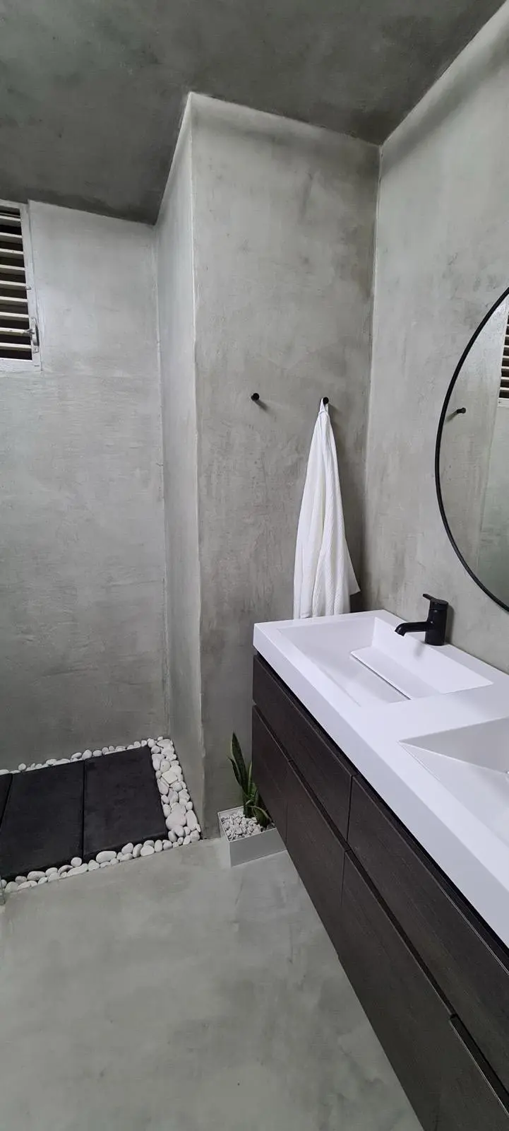 Baño moderno con ducha y superficies en cemento pulido